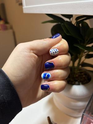 Short cobalt blue nails with white polka dot and swirl accent nails