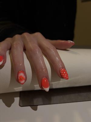 Coral almond nails with white flower and polka dot accent nails
