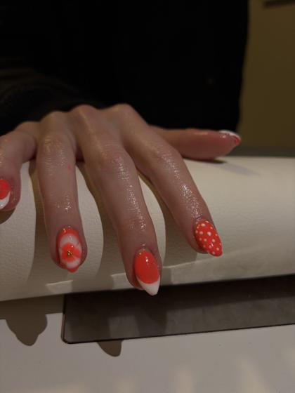 Coral almond nails with white flower and polka dot accent nails