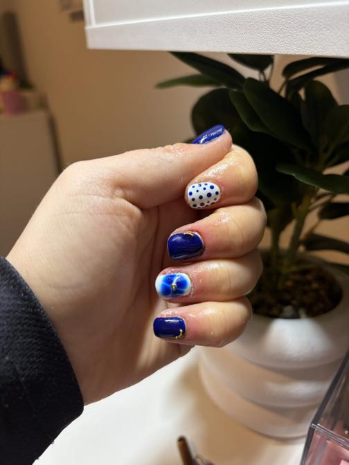Short cobalt blue nails with white polka dot and swirl accent nails