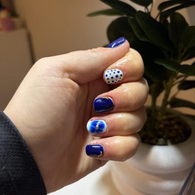 Short cobalt blue nails with white polka dot and swirl accent nails
