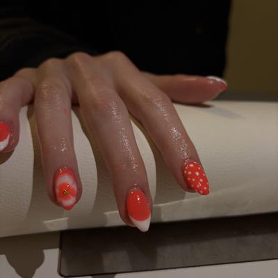 Coral almond nails with white flower and polka dot accent nails