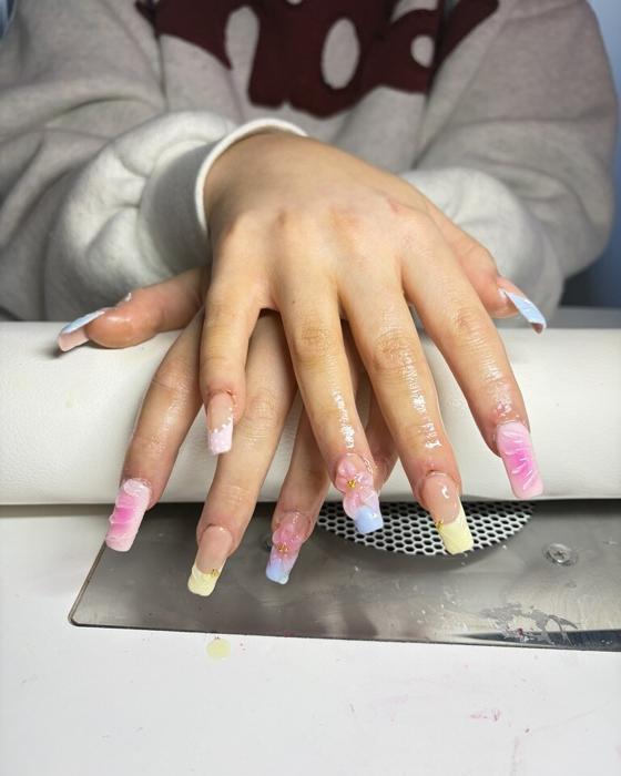 Long square nails in pastel pink, blue, and lemon marble with 3D flowers and gold beads