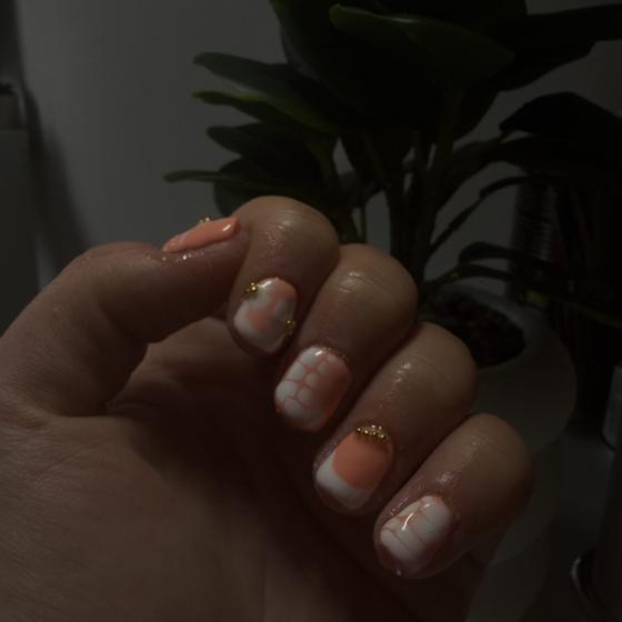 Soft peach french tips finished with fine gold glitter accents