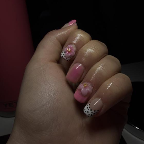 Pink nails with hand-painted 3D flowers and black dotted accents