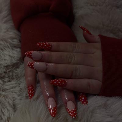 Long stiletto nails with red and white polka dot french tips